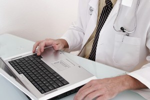 Doctor sitting at laptop computer