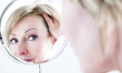 Old woman looking into mirror.